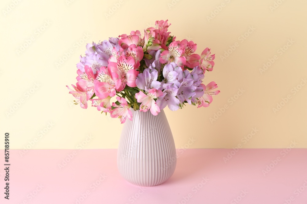 Beautiful alstroemeria flowers in vase on color background Beautiful alstroemeria flowers in vase on color background