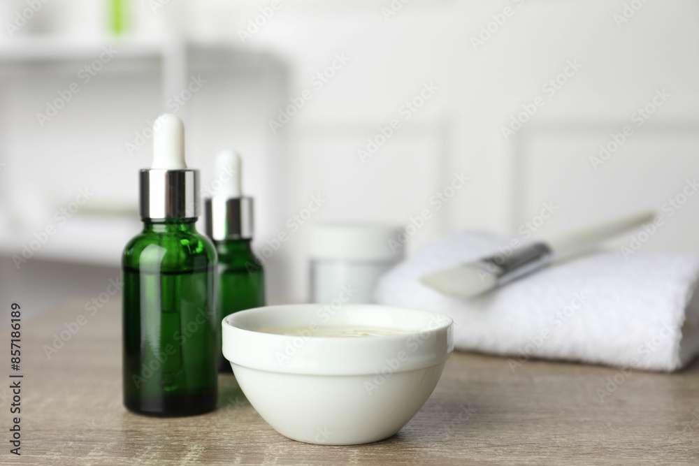 Peeling procedure. Bottles of chemical peel, bowl with liquid and brush on wooden table indoors. Space for text Peeling procedure. Bottles of chemical peel, bowl with liquid and brush on wooden table indoors. Space for text