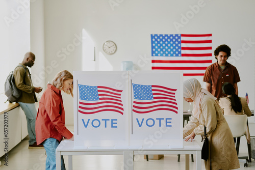 Fotografía Young Muslim and mature Caucasian women voting for candidates at polling station
