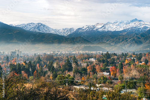 Autumn cityscape of Santiago, Chile, with colorful residential neighborhoods and the Andes Mountains in the background after rain, soft fog and clear light. Scenic urban landscape.