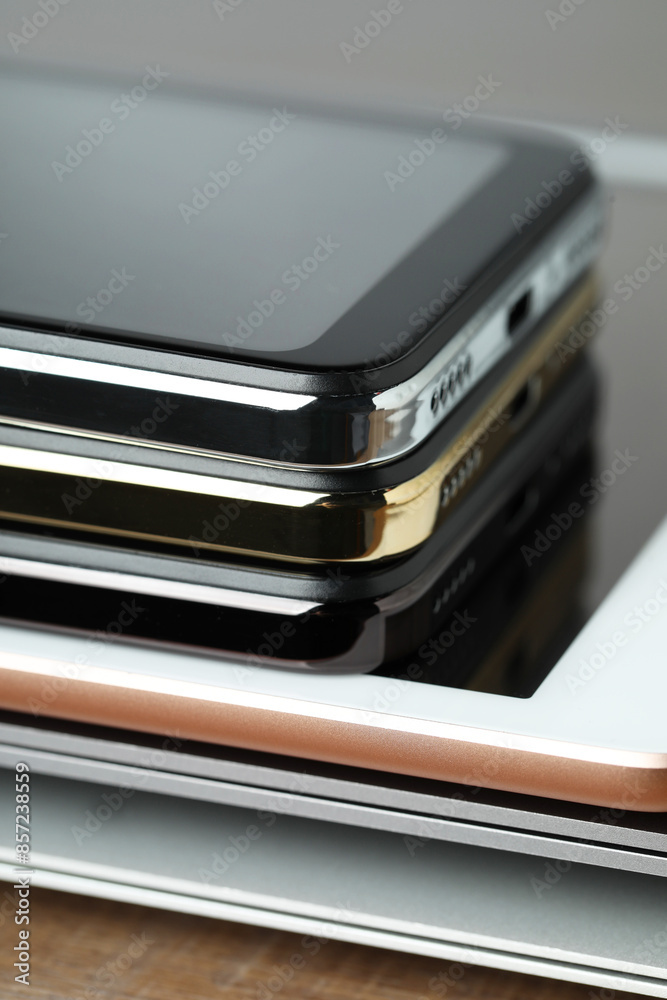 Stack of electronic devices on wooden table, closeup Stack of electronic devices on wooden table, closeup