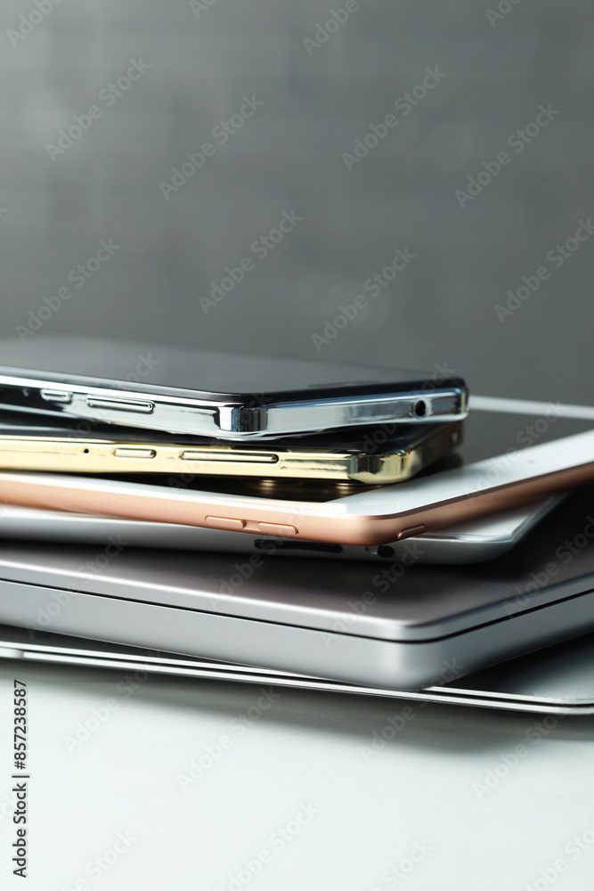 Stack of electronic devices on white table, closeup Stack of electronic devices on white table, closeup