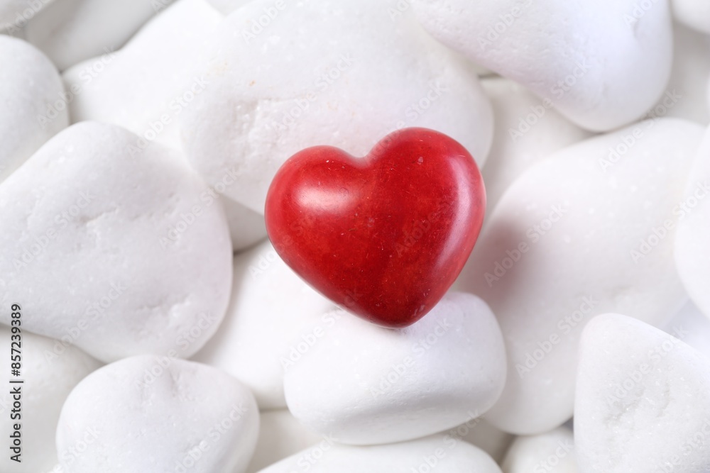 Obraz premium Decorative heart on white pebble stones, top view