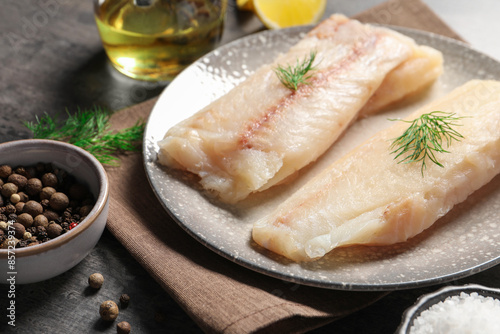 Принти на полотні Pieces of raw cod fish, dill and peppercorns on table, closeup