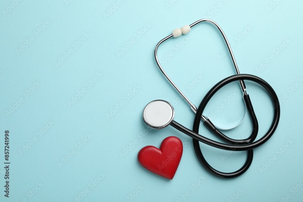 Stethoscope and red heart on light blue background, top view. Space for text Stethoscope and red heart on light blue background, top view. Space for text