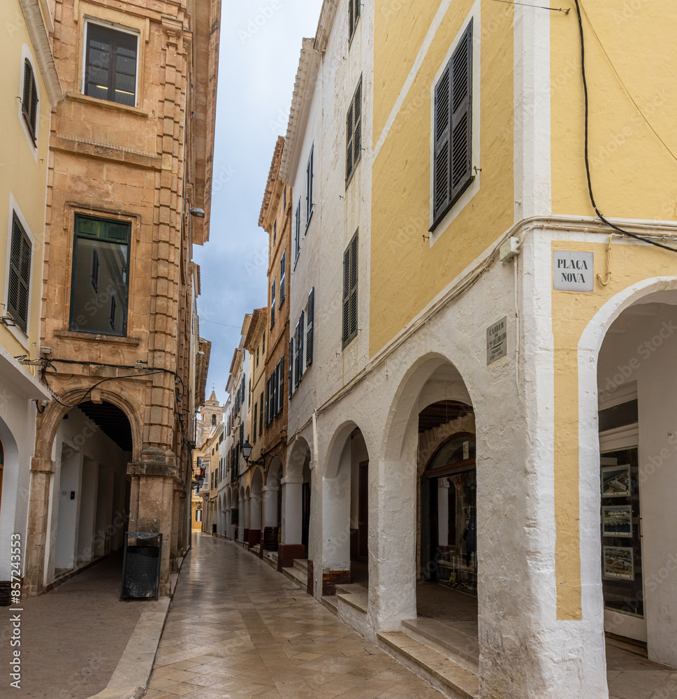 Fototapeta premium Charming and picturesque streets of Ciudadela. Cozy arcades formed by arches in various shades of color. Menorca, Spain