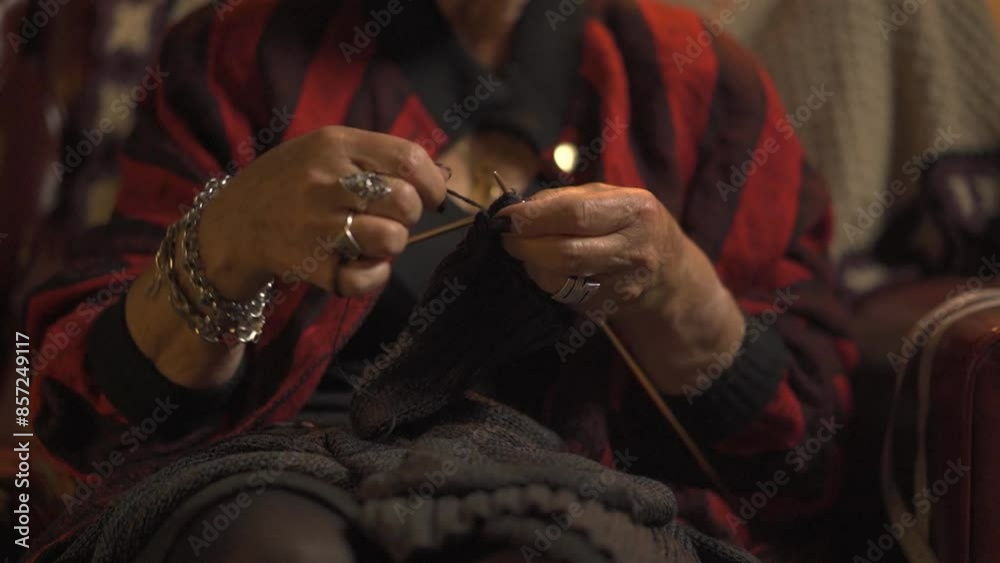 senior woman knitting sweater manually