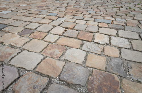 Background and texture of historic cobblestones made of stones that were individually hewn by hand. There is space for text.