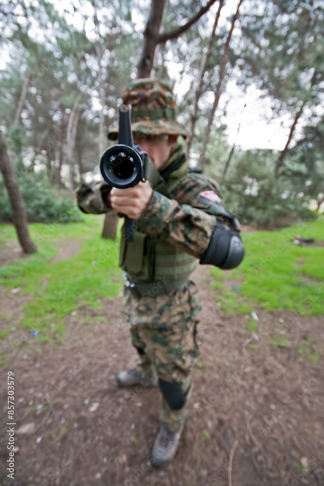A soldier wearing camouflage cloth is directing an air gun to shoot. A soldier wearing camouflage cloth is directing an air gun to shoot.