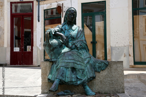 Bronze statue of Portuguese woman, Tricana de Coimbra, in the historical center Coimbra city, Portugal.