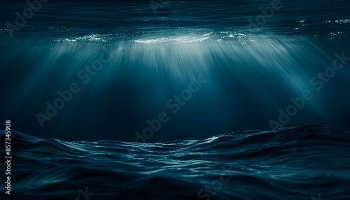 An atmospheric image capturing light rays penetrating the deep blue ocean, creating a mysterious effect underwater