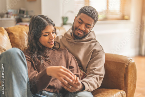 Couple Relaxing On Leather Couch At Home