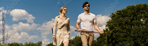 Canvas Print A young couple in elegant clothing walks across a luxurious golf course, enjoying the refined atmosphere