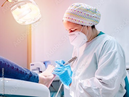 Female podiatrist doing chiropody in her podiatry clinic. Selective focus photo