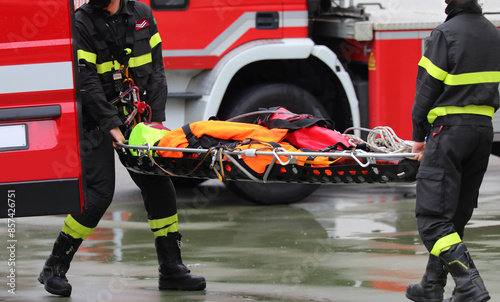 Firefighters carry the injured man on a stretcher after rescuing him in the house