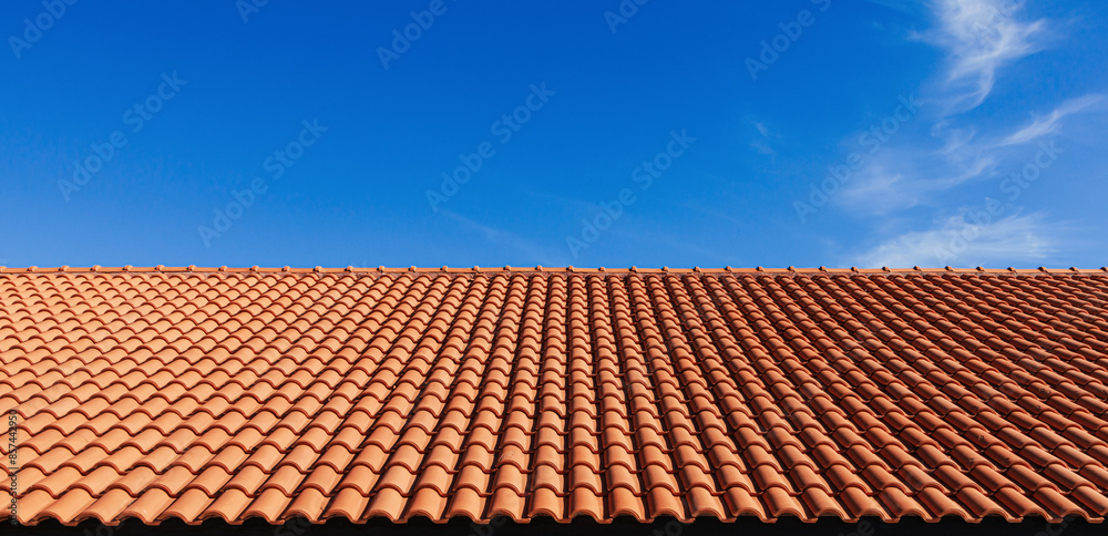 Clay tile roof. Banner with orange clay tile roof close-up on blue sky background with space for text, copy space Clay tile roof. Banner with orange clay tile roof close-up on blue sky background with space for text, copy space