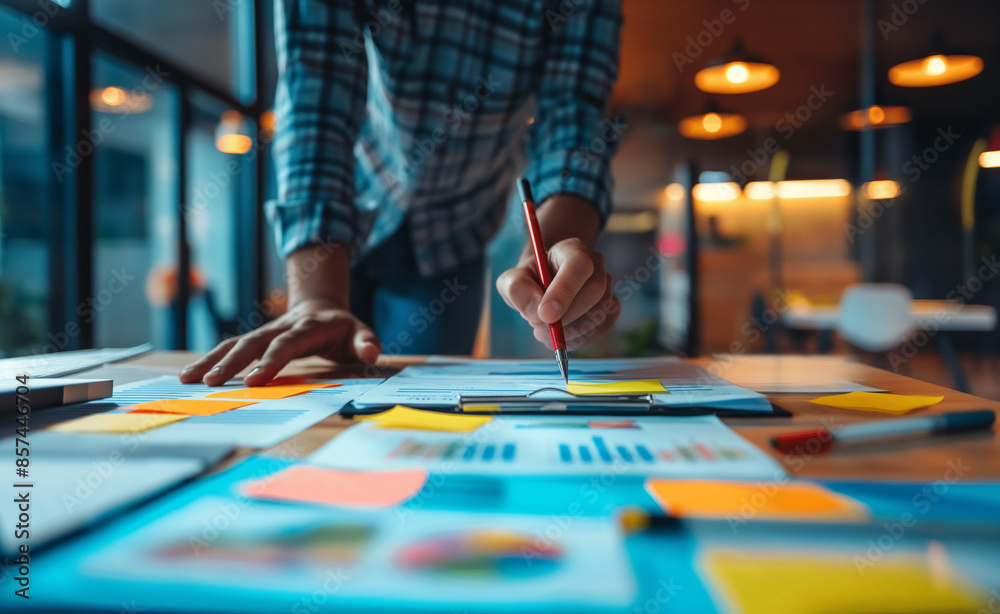 Person writing on papers with a laptop and colorful sticky notes on the desk.
Person writing on papers with a laptop and colorful sticky notes on the desk.