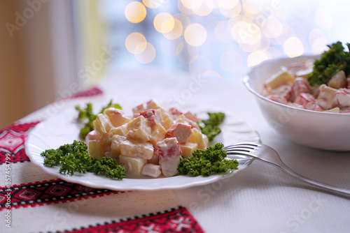 Obraz na płótnie Homemade crab stick salad typical of modern Ukrainian cuisine and other Eastern European cuisines Traditional Ukrainian food on the table with embroidered tablecloth. w salonie