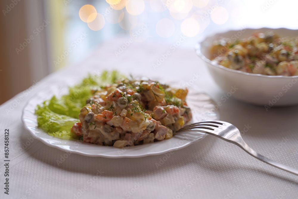 Olivier salad, traditional salad dish of post Soviet cuisine. Traditional Ukrainian food on the table with embroidered tablecloth.