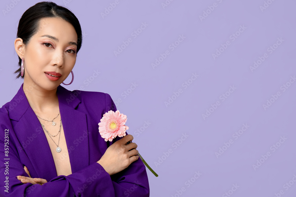 Beautiful young Asian woman with pink gerbera flower on lilac background Beautiful young Asian woman with pink gerbera flower on lilac background