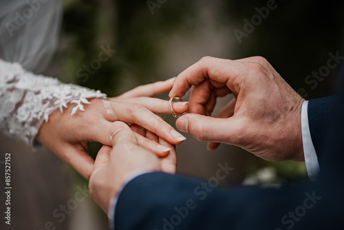 Newly wed couple giving a wedding ring. Cloe up detail of wedding ring and hands.