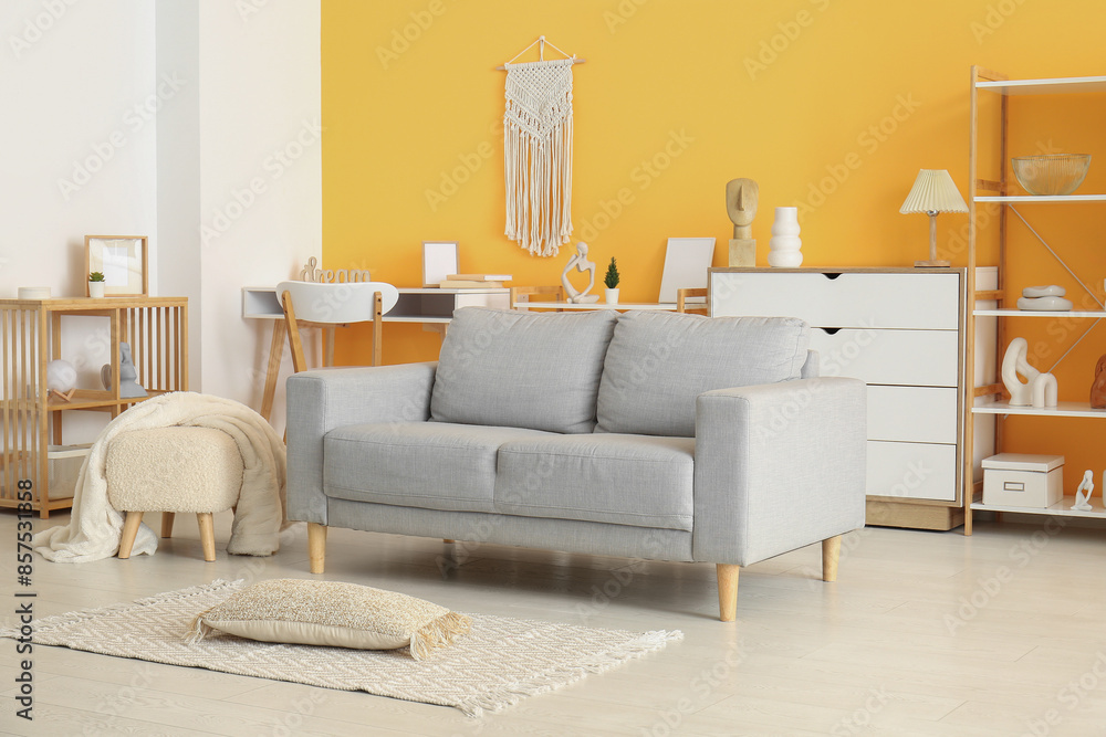Fototapeta premium Interior of living room with soft grey sofa and footrest