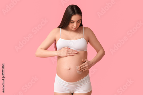 Young pregnant woman applyi...