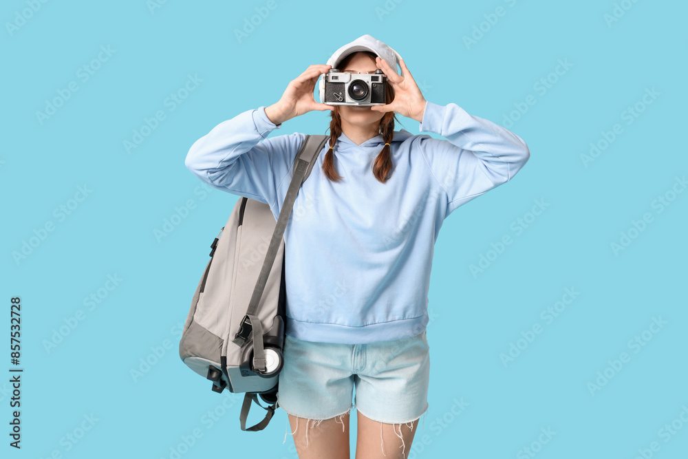 Young woman taking pictures on blue background. Travel concept Young woman taking pictures on blue background. Travel concept