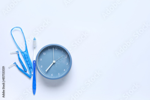 Alarm clock, braces brush and toothbrush on white background