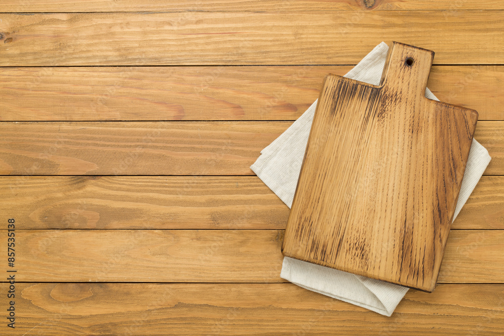Cutting board with napkin on wooden background, top view Cutting board with napkin on wooden background, top view