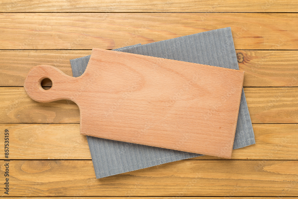 Cutting board with napkin on wooden background, top view Cutting board with napkin on wooden background, top view