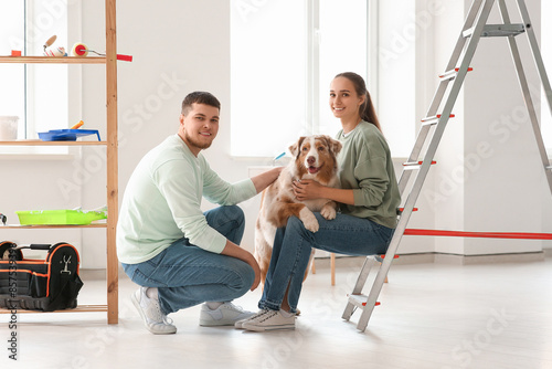 Happy young couple with cute dog during repair of their new house