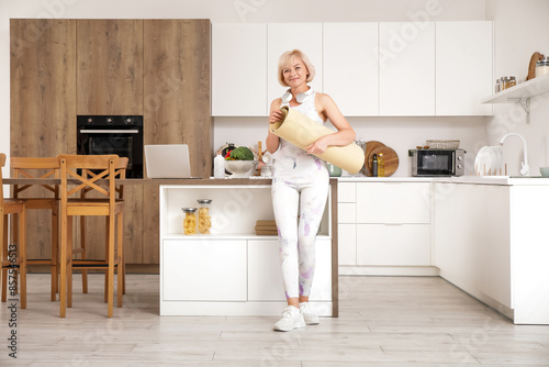 Mature woman holding yoga m...