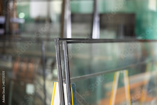 фотографія Close-up of insulated glass units stacked on support stand in workshop, with var