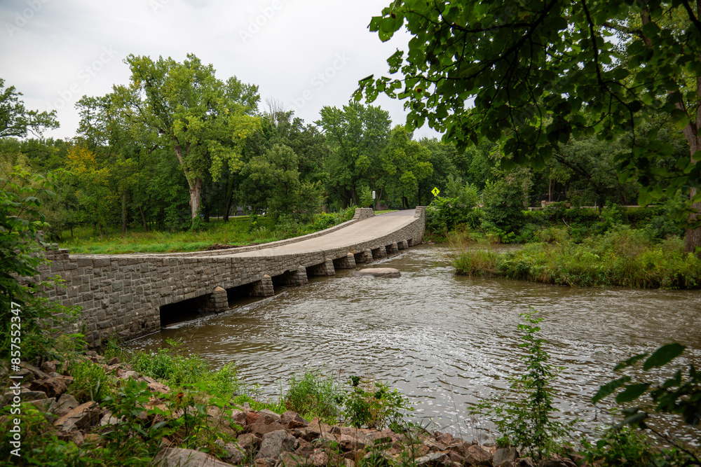 Unique Rock Bridge with Downward Dip Over a Beautiful River Surrounded by Trees – Scenic Nature and Architectural Design Unique Rock Bridge with Downward Dip Over a Beautiful River Surrounded by Trees – Scenic Nature and Architectural Design