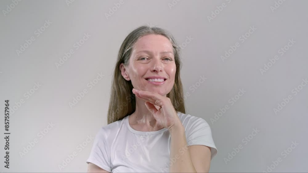 Portrait: beautiful old woman smiling and laughing in the studio. Middle aged senior female is flirting, healthy white teeth, smooth moisturized skin, long grey hair. Concept of anti-aging skincare Portrait: beautiful old woman smiling and laughing in the studio. Middle aged senior female is flirting, healthy white teeth, smooth moisturized skin, long grey hair. Concept of anti-aging skincare