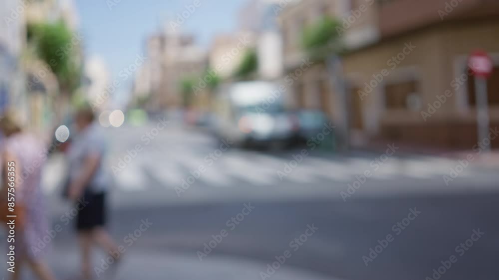 Blurry city street with unidentified people and vehicles, sunny day provides bright urban backdrop suggesting summer or spring Blurry city street with unidentified people and vehicles, sunny day provides bright urban backdrop suggesting summer or spring
