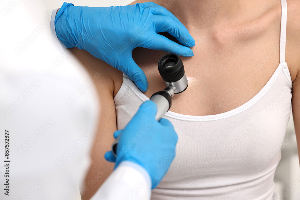 Dermatologist with dermatoscope examining patient, closeup view Dermatologist with dermatoscope examining patient, closeup view