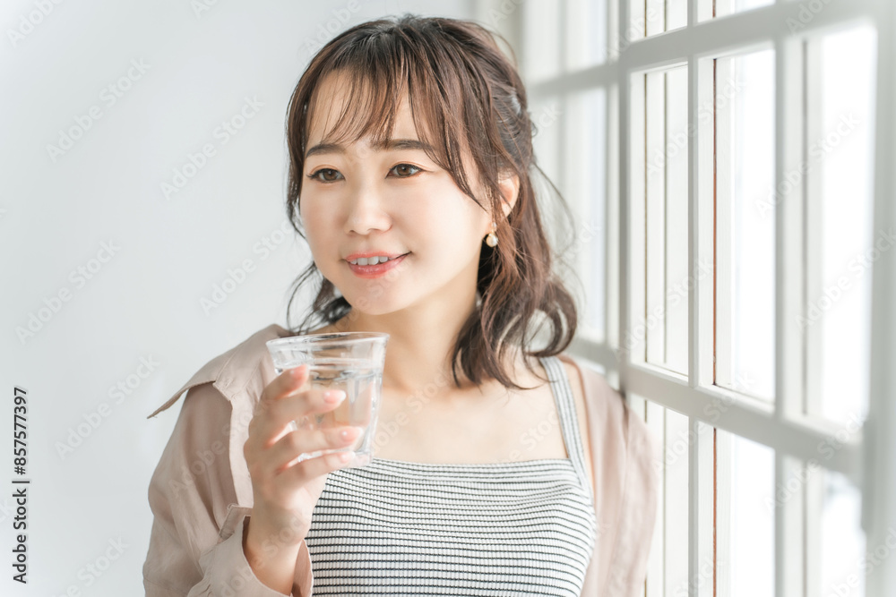 水・白湯・ミネラルウォーターを飲むアジア人女性（水分補給）
