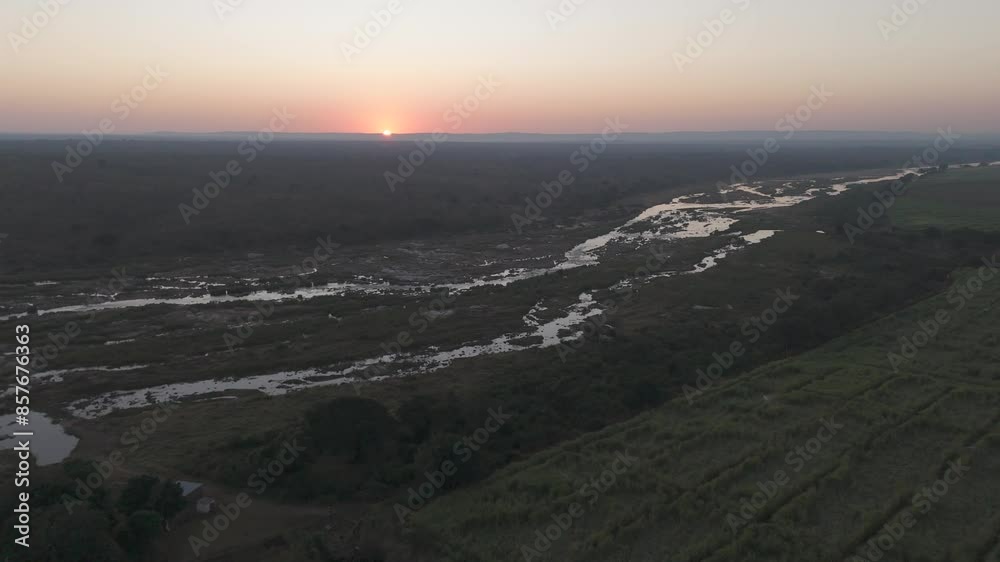 Drone flight over seasonal Crocodile River at sunrise bordering sugar cane farms, Crocodile River, Kruger National Park. Drone flight over seasonal Crocodile River at sunrise bordering sugar cane farms, Crocodile River, Kruger National Park.