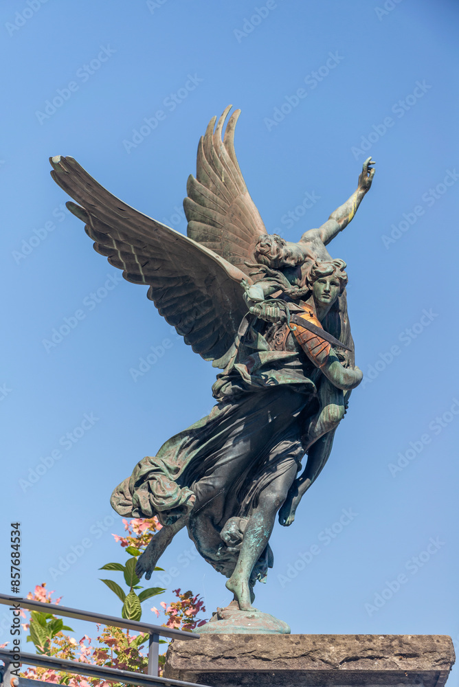 Fototapeta premium Close up of Bronze Angel Statue with sky background, Lucerne, Switzerland, 16 Aug 2022