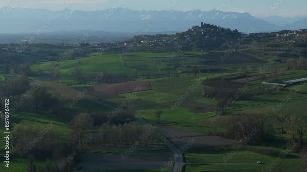 stunning reveal of misty hill town Gabiano, Italy in the morning, with high mountain vistas in the background stunning reveal of misty hill town Gabiano, Italy in the morning, with high mountain vistas in the background