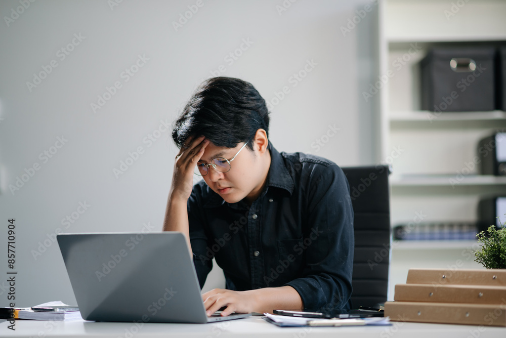 Businessman who is tired and overthinking from working with tablet and laptop Businessman who is tired and overthinking from working with tablet and laptop