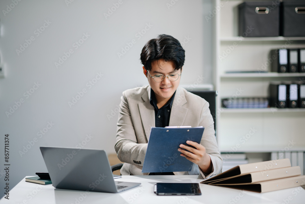 Young businessman working with working notepad, tablet and laptop documents talking on the smartphone, tablet and laptop Young businessman working with working notepad, tablet and laptop documents talking on the smartphone, tablet and laptop