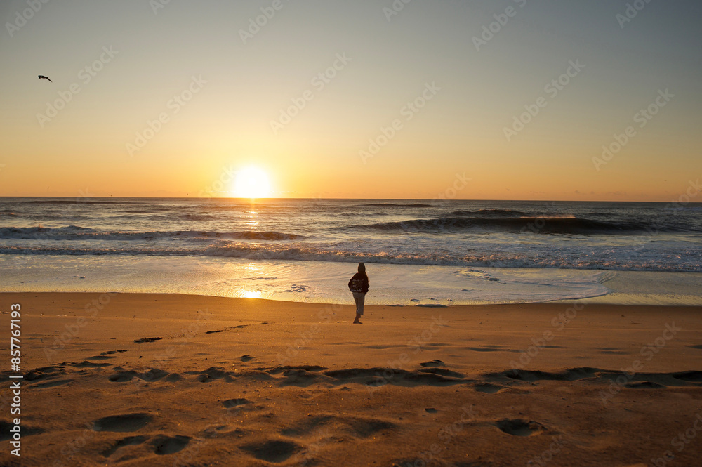 Young child walking towards ocean beautiful sunrise Young child walking towards ocean beautiful sunrise
