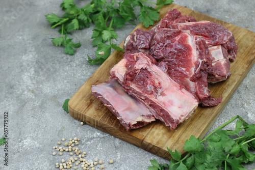 Iga sapi mentah or raw beef ribs  on preparation for cooking with some spice. Beef ribs on chopping board with wooden rustic background. photo