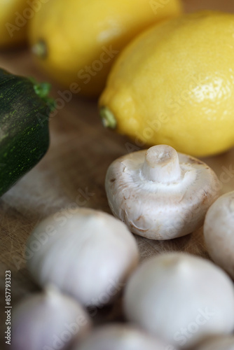 Scandinavian summer, fall season cuisine. Ingredients for a healthy meal: potatoes, garlic, zucchini and lemons on a wooden rustic cutting board. Fresh raw vegetables from season's harvest. Closeup.