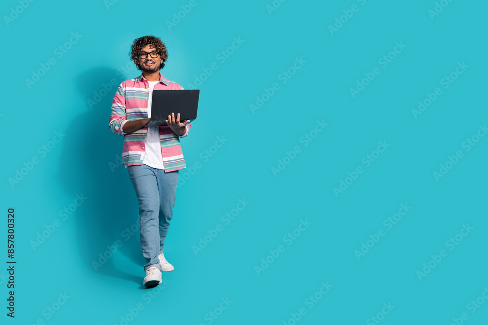 Photo of cheerful nice man wear trendy striped clothes use modern device empty space isolated on cyan color background Photo of cheerful nice man wear trendy striped clothes use modern device empty space isolated on cyan color background