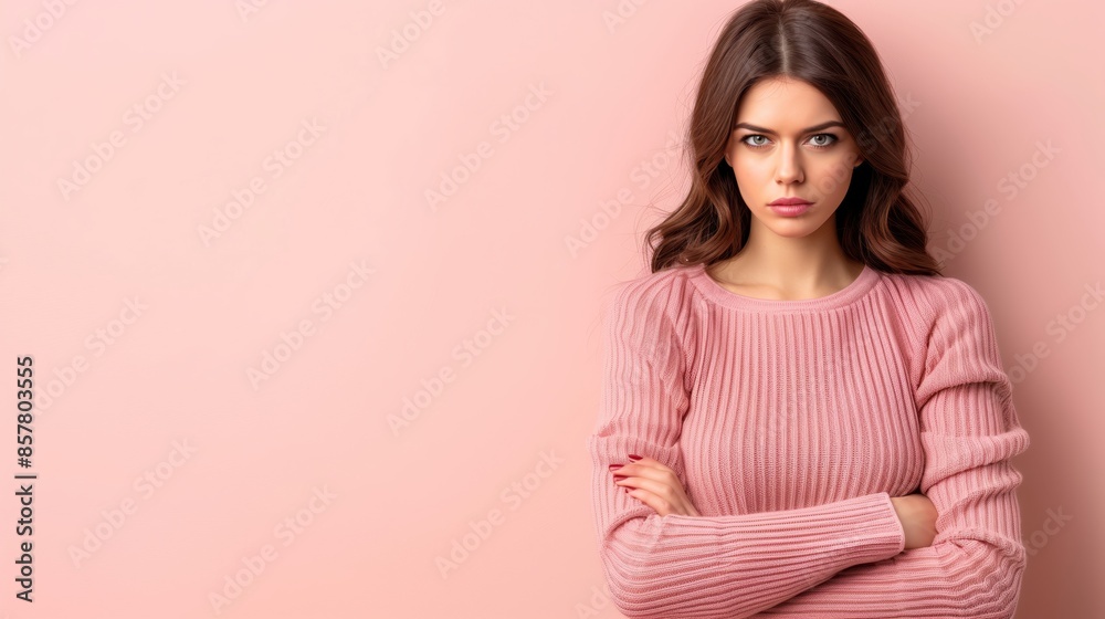 Woman with arms crossed and an intense expression, on pink pastel background with copyspace Woman with arms crossed and an intense expression, on pink pastel background with copyspace