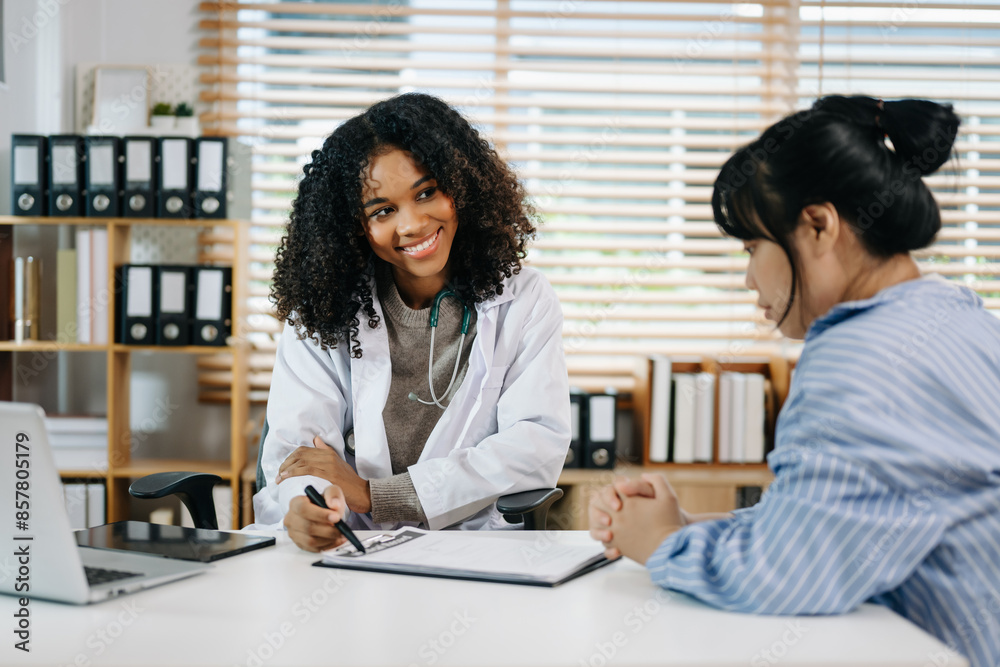 Asia female doctor using clipboard is delivering great news talk discuss results or symptoms with female patient Asia female doctor using clipboard is delivering great news talk discuss results or symptoms with female patient